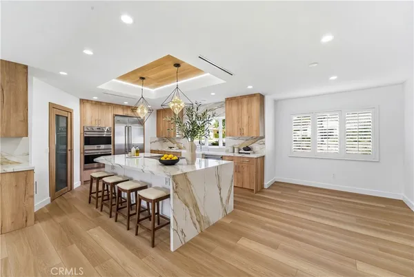 a open kitchen with stainless steel appliances granite countertop a stove and a refrigerator