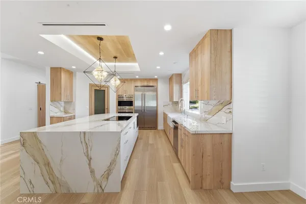 a large kitchen with a large counter top appliances and cabinets