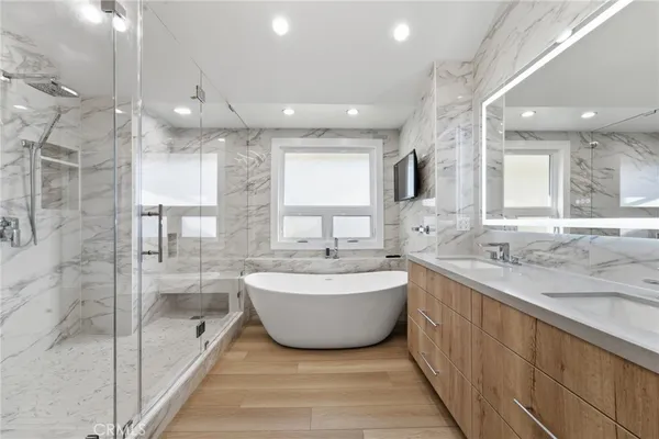 a spacious bathroom with a large tub sink shower and mirror