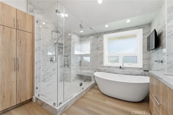 a bathroom with a tub a sink shower and mirror