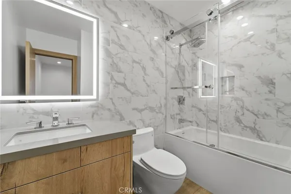 a bathroom with a sink toilet vanity and shower