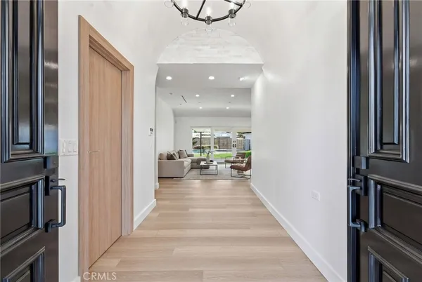 a view of a hallway with wooden floor and furniture