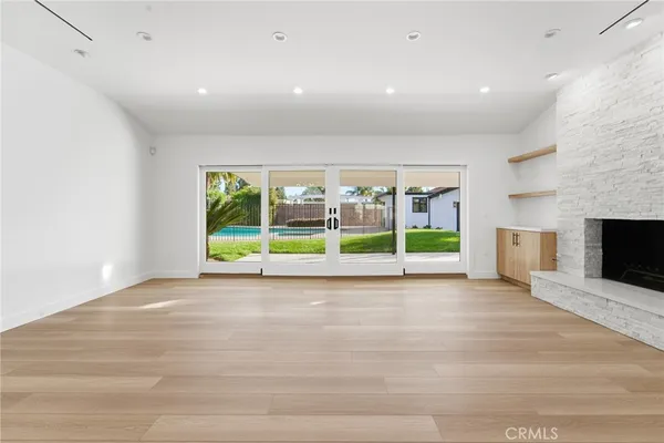 a view of an empty room with a fireplace and a window