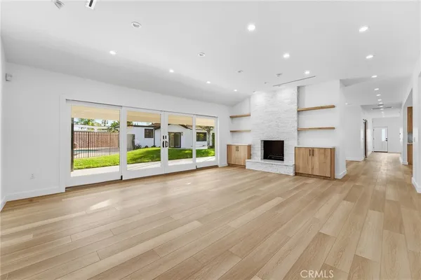 a view of empty room with wooden floor and fireplace