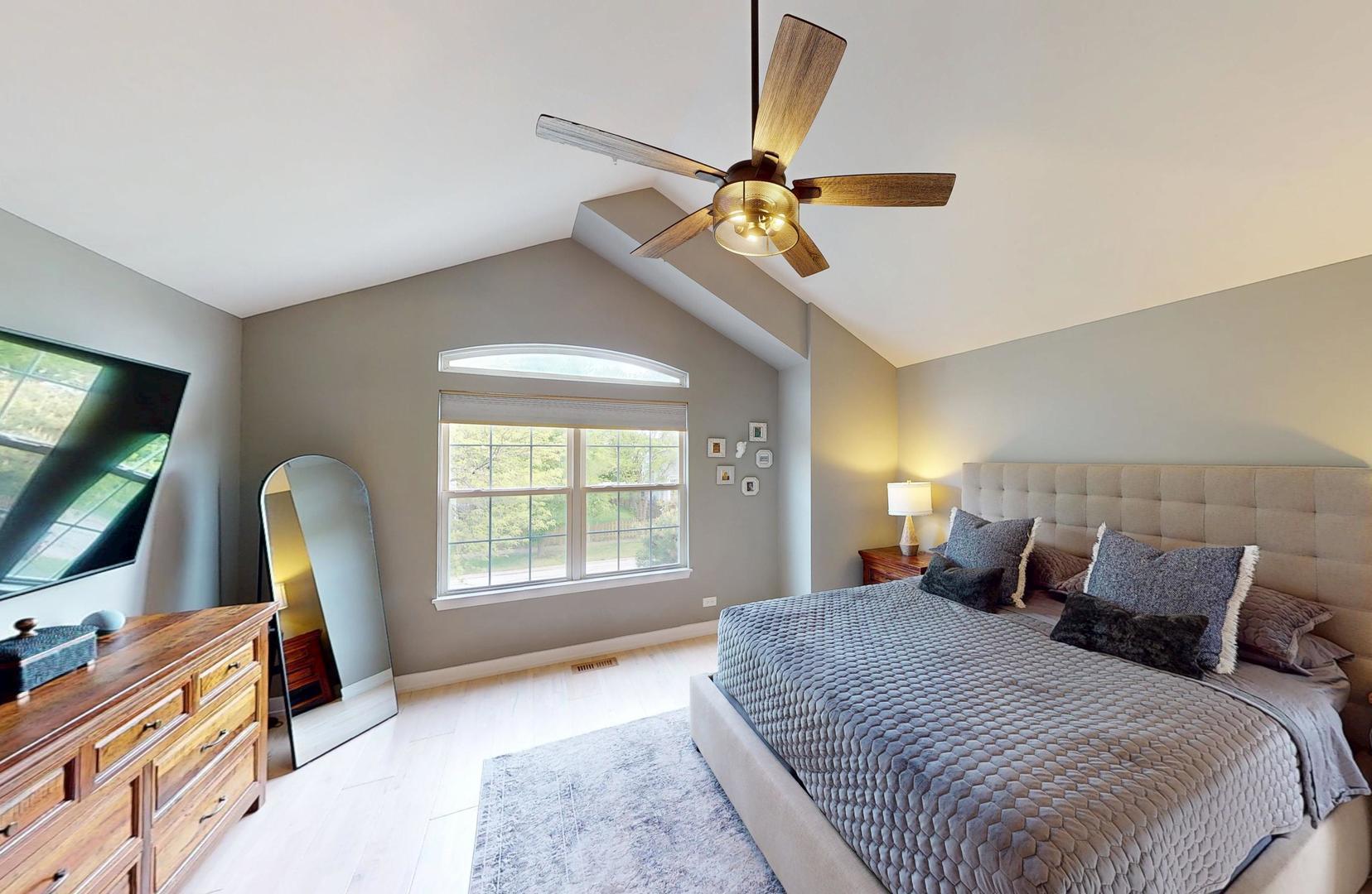 2207 Periwinkle Lane Naperville, IL 60540 - Photo 15 of 40 a bedroom with a bed a flat screen tv and a chandelier