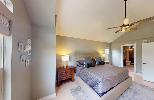 a bedroom with a large bed and a chandelier