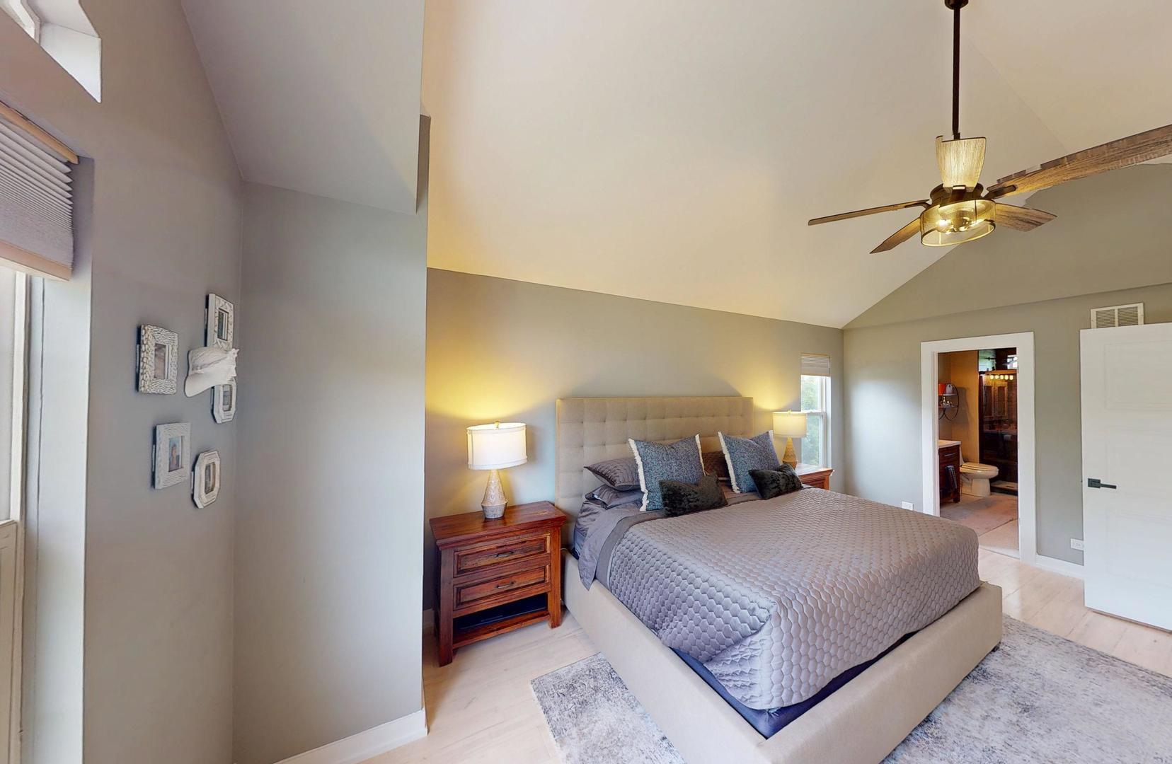 2207 Periwinkle Lane Naperville, IL 60540 - Photo 16 of 40 a bedroom with a large bed and a chandelier