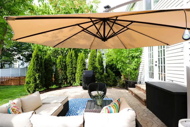 a view of a patio with a table and chairs under an umbrella