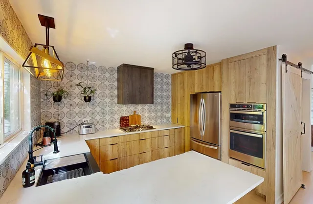 a kitchen with stainless steel appliances a refrigerator sink and stove