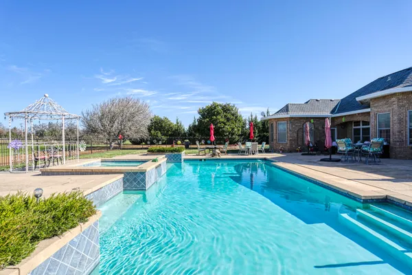 a view of swimming pool with outdoor seating and a yard