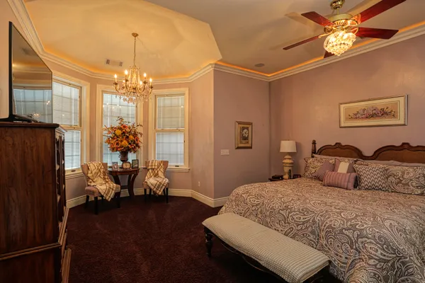 a bedroom with a bed and a large mirror on the dresser