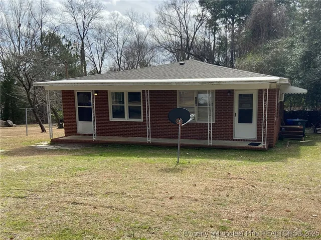a backyard of a house with barbeque oven and table