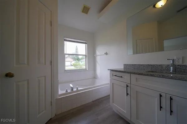 a bathroom with a granite countertop sink a toilet and shower