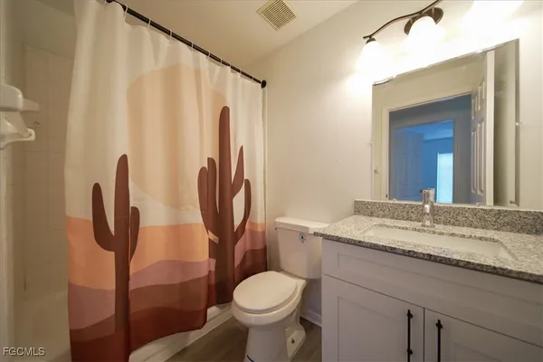 a bathroom with a granite countertop toilet sink and a mirror