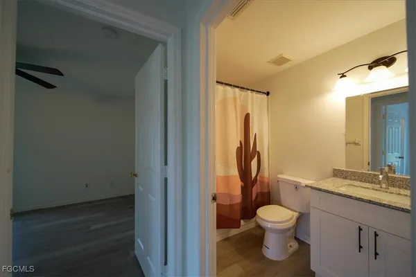 a bathroom with a granite countertop toilet sink and a mirror
