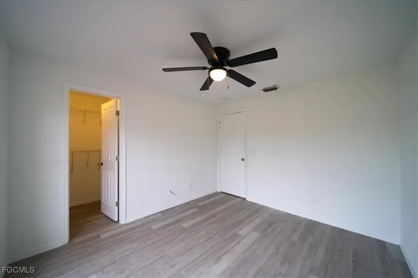 a view of a room with wooden floor and a ceiling fan