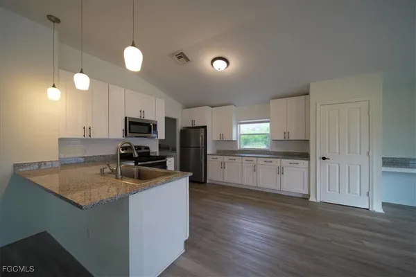 a large kitchen with a center island and stainless steel appliances