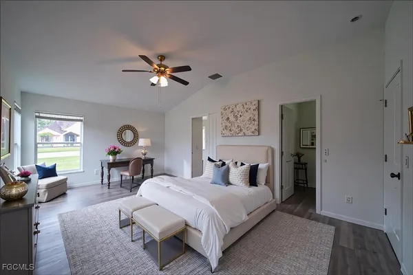 a bedroom with a bed a chandelier and a dresser next to a window