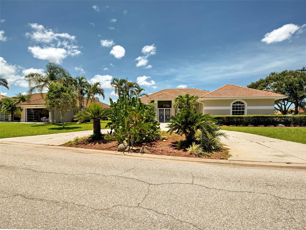 a front view of a house with a yard and potted plants