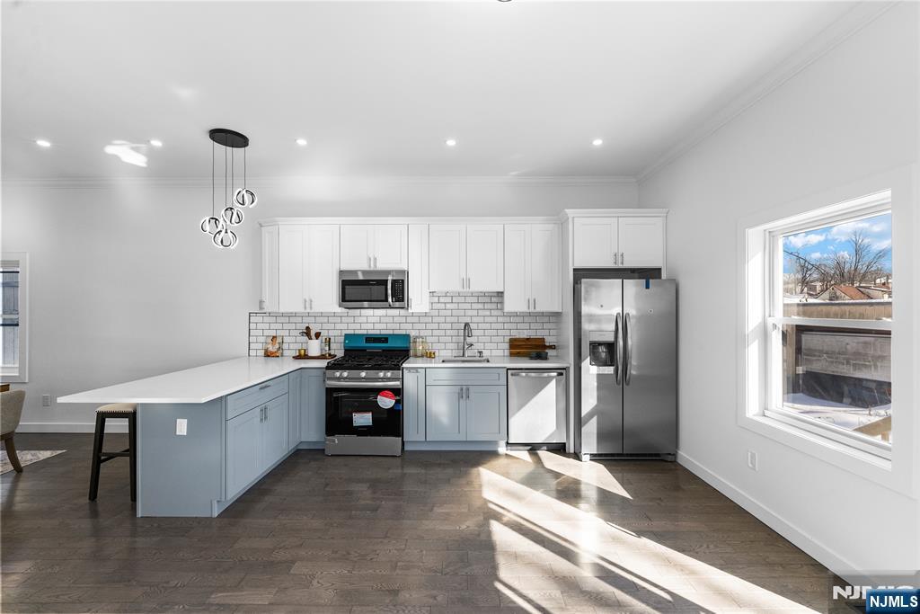 784 Valley Street Union, NJ 07088 - Photo 14 of 49 a kitchen with stainless steel appliances kitchen island granite countertop a refrigerator oven a sink dishwasher and white cabinets with wooden floor