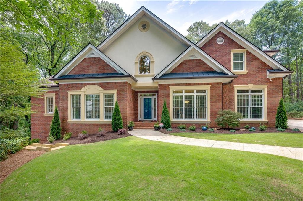 820 Wesley Oak Road Northwest Sandy Springs, GA 30328 - Photo 1 of 1 a front view of a house with a yard
