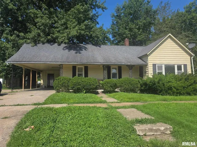 a front view of a house with a yard and trees
