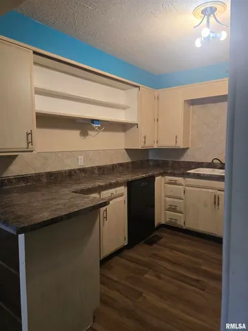 a kitchen with granite countertop a sink cabinets and stainless steel appliances
