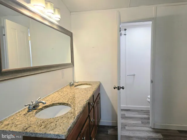 a bathroom with a granite countertop sink and a mirror