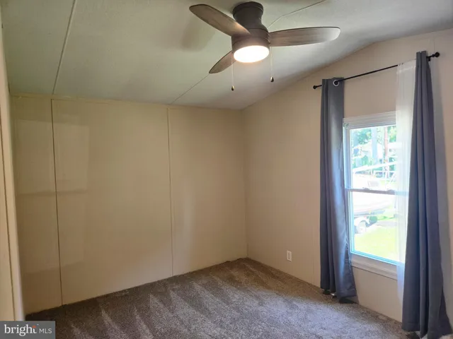 an empty room with a window and a ceiling fan