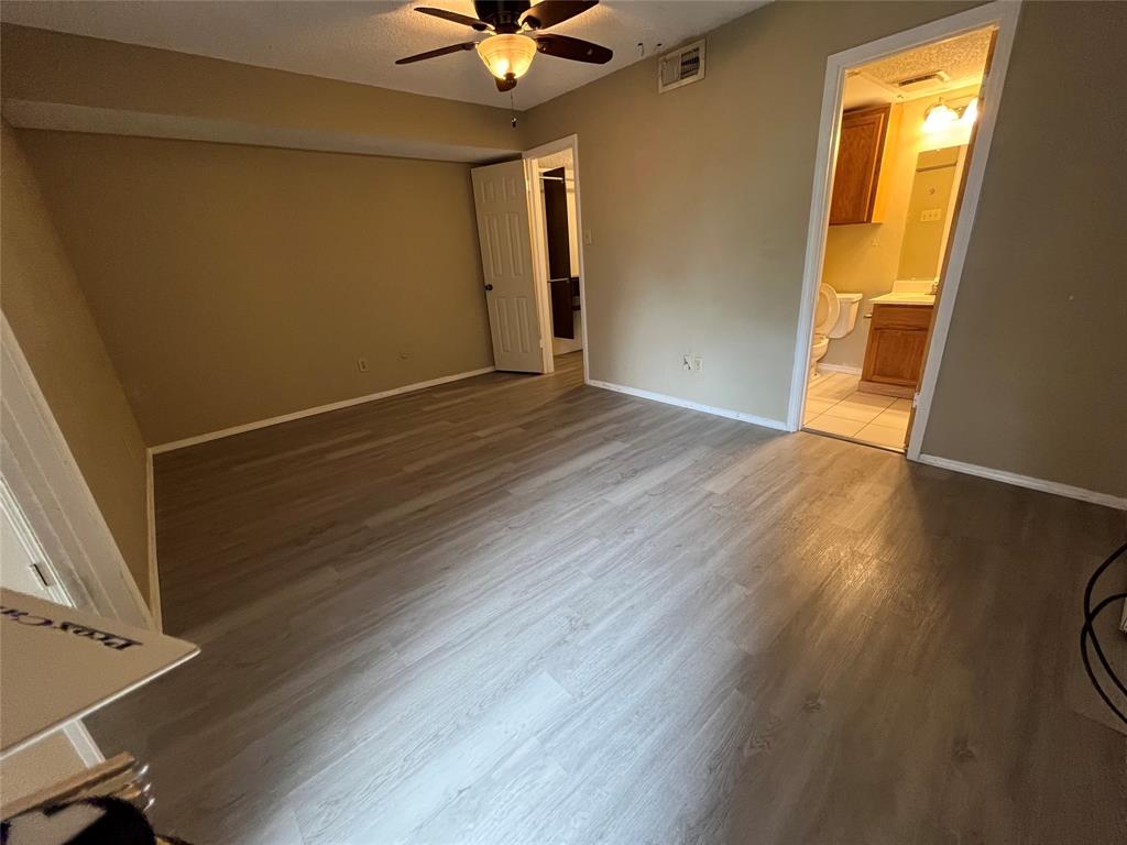 9811 Walnut Street, Unit 201 Dallas, TX 75243 - Photo 2 of 9 a view of an empty room with wooden floor and a window