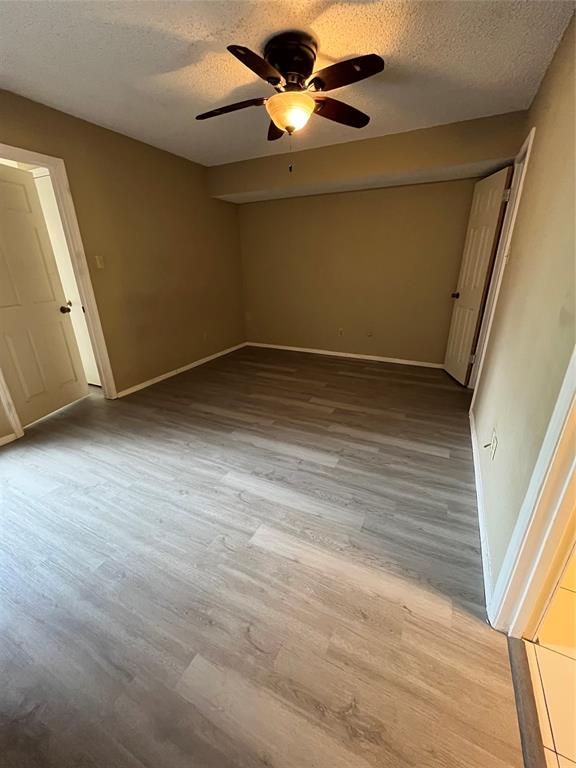 9811 Walnut Street, Unit 201 Dallas, TX 75243 - Photo 3 of 9 a view of a room with wooden floor and a ceiling fan