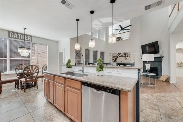 a kitchen with kitchen island granite countertop a sink a counter top space appliances and cabinets