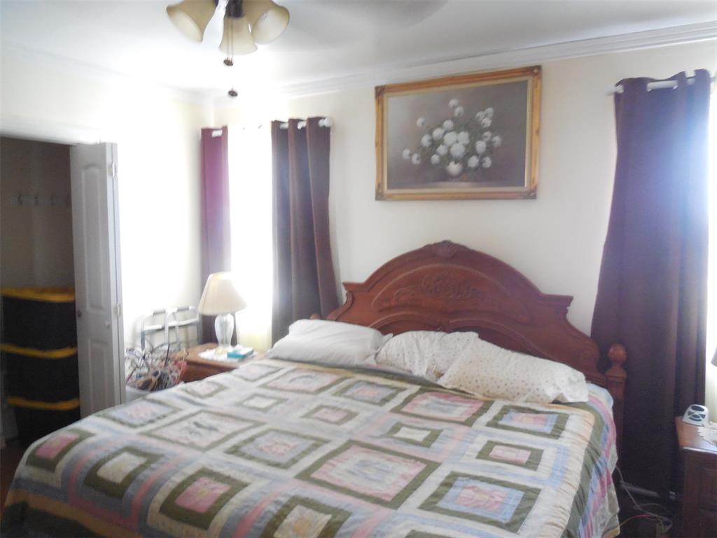 12436 County Road 134 Ranger, TX 76470 - Photo 16 of 32 a bedroom with a large bed and a chandelier