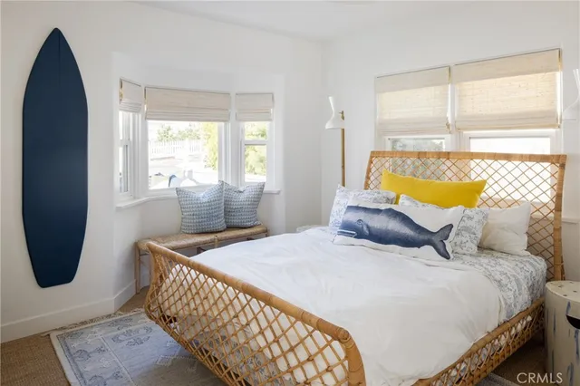 a bedroom with a bed a couch and windows