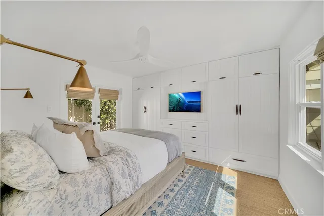 a spacious bedroom with a bed and a flat screen tv