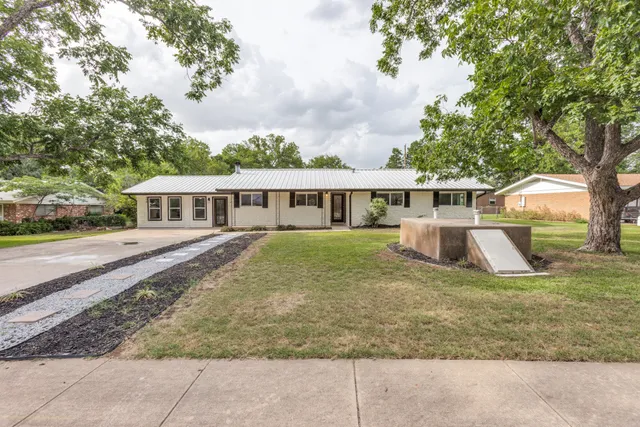 a view of house with a yard and sitting area