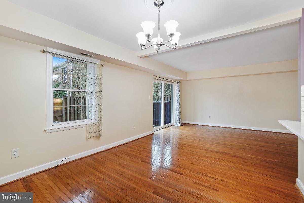 10867 Bucknell Drive, Unit 52 Silver Spring, MD 20902 - Photo 12 of 33 a view of an empty room with wooden floor and a window