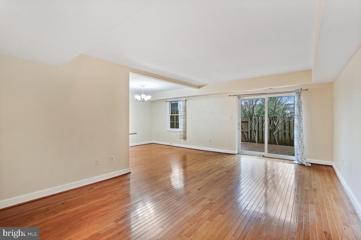10867 Bucknell Drive, Unit 52 Silver Spring, MD 20902 - Photo 15 of 33 a view of an empty room with wooden floor and a window