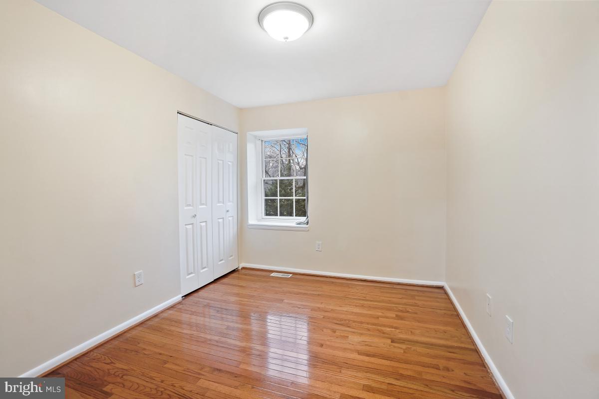 10867 Bucknell Drive, Unit 52 Silver Spring, MD 20902 - Photo 18 of 33 an empty room with wooden floor and windows
