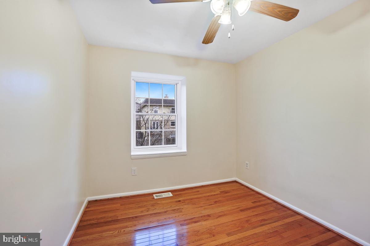 10867 Bucknell Drive, Unit 52 Silver Spring, MD 20902 - Photo 19 of 33 a view of an empty room with wooden floor and a window
