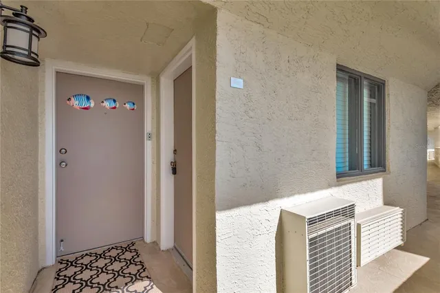 a view of a hallway with wooden floor and a bathroom