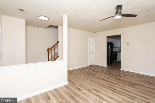 a view of an empty room with wooden floor