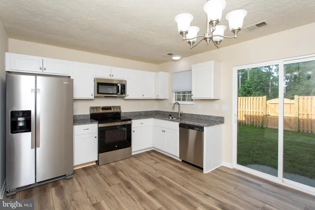 a kitchen with a refrigerator a sink dishwasher a stove and a microwave oven with cabinets