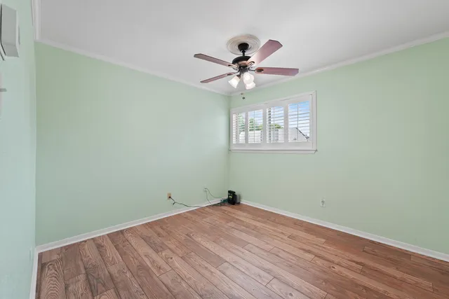 a view of a room with wooden floor and ceiling fan