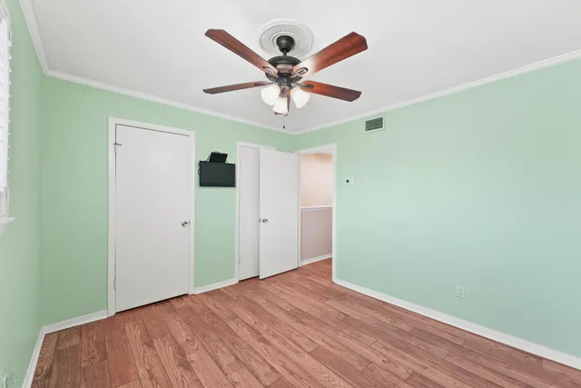 a view of a hallway with wooden floor and staircase