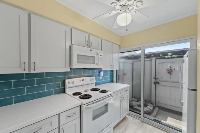 a kitchen with a sink a stove cabinets and wooden floor