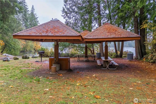a view of a patio with table and chairs under an umbrella with a large tree