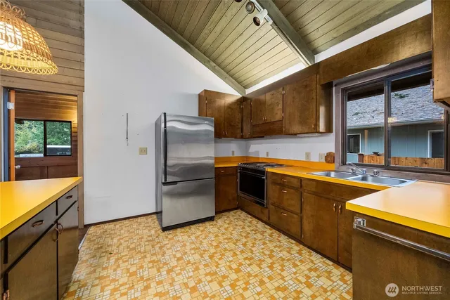 a kitchen with stainless steel appliances granite countertop a refrigerator and a stove top oven