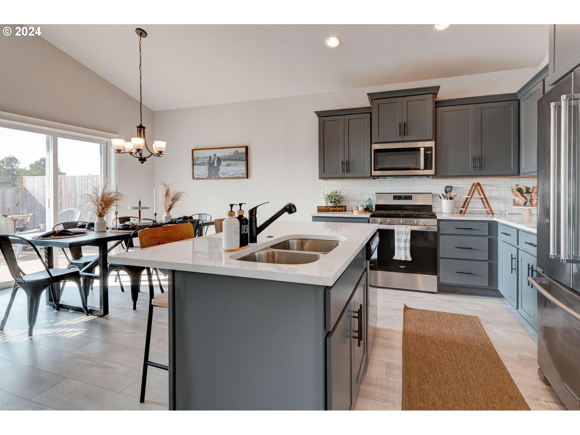 514 Merlot Street Amity, OR 97101 - Photo 12 of 33 a kitchen with stainless steel appliances granite countertop a stove top oven a sink a dining table and chairs