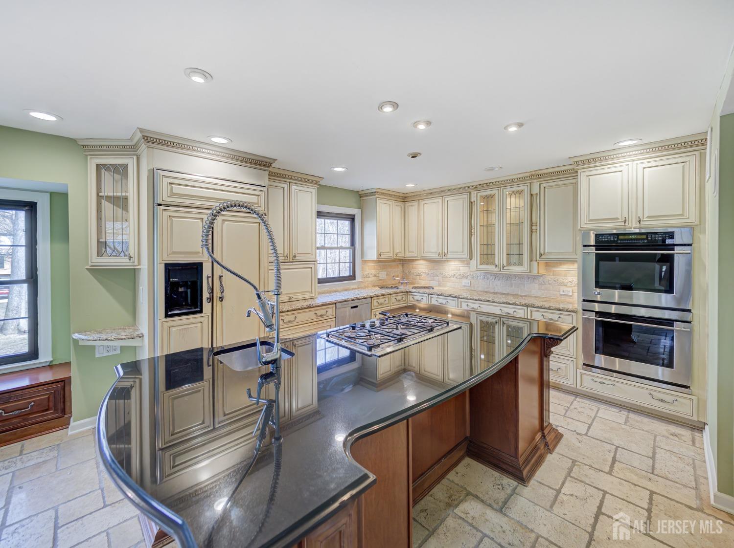 a kitchen with stainless steel appliances kitchen island granite countertop a stove and a sink